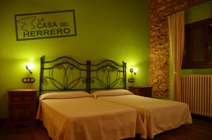 ein Schlafzimmer mit einem Bett mit einer grünen Wand in der Unterkunft La Casa del Herrero in El Poyo