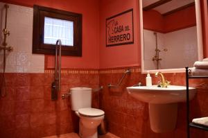 ein Badezimmer mit Toilette, Waschbecken und Spiegel in der Unterkunft La Casa del Herrero in El Poyo + 32 Fotos