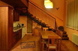 una cocina con una mesa de madera y una escalera en La Casa del Herrero, en El Poyo