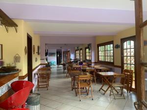 a restaurant with tables and chairs in a room at Hotel Canto da Enseada in Guarujá