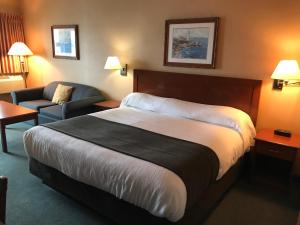 a hotel room with a large bed and a couch at Beach Gardens Resort and Marina in Powell River