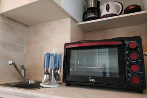 a microwave sitting on a kitchen counter next to a sink at Psychiko's View in Athens