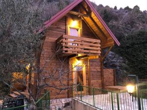 a small wooden cabin with lights on the porch at Apartments "Old house Pajovic" in Virpazar
