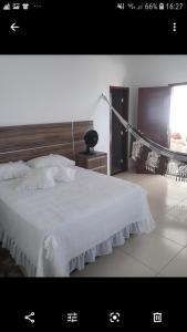 1 dormitorio con cama blanca y cabecero de madera en Cantinho Serrano, en Serra de São Bento