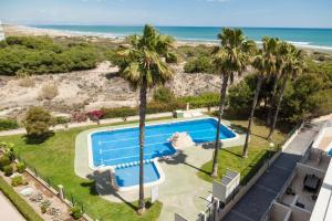 - une vue aérienne sur la piscine et la plage dans l'établissement 003 Apartament Puerto Romano, à La Mata