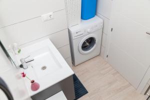 a bathroom with a sink and a washing machine at Apartament Puerto Romano, La Mata, close to the beach plus parking space in the underground garage in La Mata