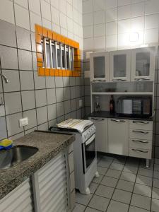 a kitchen with a stove and a sink in it at Edf. Iracema Costa in Recife