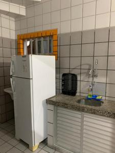 a kitchen with a white refrigerator and a sink at Edf. Iracema Costa in Recife