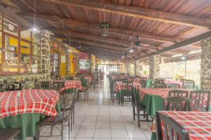 an empty restaurant with red and green tables and chairs at OYO Hotel Coyopolan in Xico