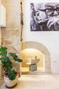 a living room with a plant and a picture of a man at Basseo33 in Lecce