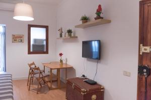 uma sala de estar com uma mesa e uma televisão na parede em Sweet BCN Studio with Terrace em Barcelona