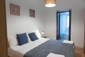 a bedroom with a large bed with blue pillows at Sweet BCN Studio with Terrace in Barcelona