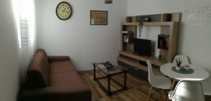 ein Wohnzimmer mit einem Sofa, einem Tisch und einer Uhr in der Unterkunft Apartman Gušt in Herceg-Novi