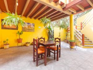 a dining room with a table and chairs and a yellow wall at Hotel Posada San Rafael in Oaxaca City