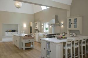 una cocina con armarios blancos y encimeras blancas en Goudhurst Oast by Bloom Stays, en Goudhurst