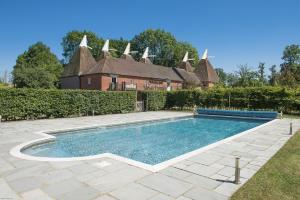 a swimming pool in the yard of a house at Goudhurst Oast by Bloom Stays in Goudhurst