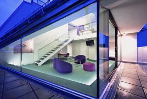 a room with a glass window with purple chairs and stairs at Hotel König von Ungarn in Vienna