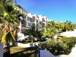 un gran edificio blanco con palmeras delante en Bertur Font Nova, en Peñíscola