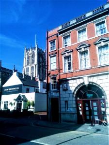 un grand bâtiment en briques avec une tour d'horloge en arrière-plan dans l'établissement Hull Trinity Backpackers, à Hull