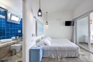 a bedroom with a bed and a bathroom with a sink at Arbatax Park Resort - Telis in Àrbatax