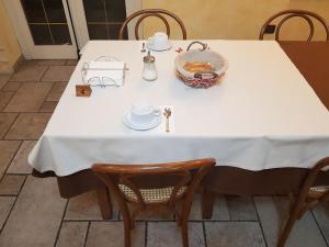 ein weißer Tisch mit Stühlen und eine Schüssel Essen darauf in der Unterkunft B&B IL FILO DI ARIANNA in LʼAquila