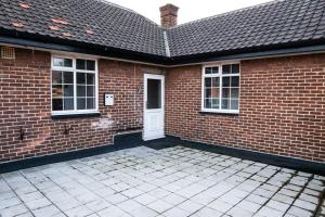a brick house with a white door and windows at Luke Stays - Front Street in Newcastle upon Tyne