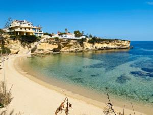 a beach with a house on top of a cliff at Il Paradiso Sul Mare in Siracusa