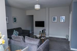 a living room with two couches and a tv at Luke Stays - Front Street in Newcastle upon Tyne