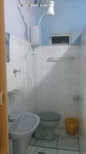 y baño con aseo y lavamanos. en Pousada Alquidora en São Thomé das Letras
