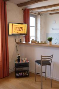 a kitchen with a chair and a sign on the wall at Appartement A-Mi-Chemin - Centre-ville de Tournus in Tournus