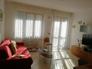 un soggiorno con divano rosso e TV di IL GIRASOLE a Tirano