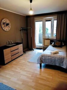 a bedroom with a bed and a sink and a clock at Przyjemna Miejscówka in Gorzów Wielkopolski