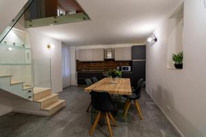 una sala da pranzo e una cucina con tavolo e sedie in legno di Dadà House a Catania