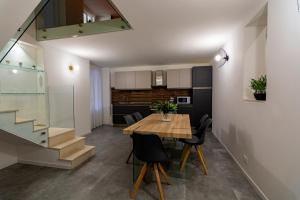 a dining room and kitchen with a wooden table and chairs at Dadà House in Catania