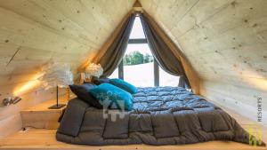 un letto in una stanza con soffitto in legno di Chalet des Marmottes a Besse-et-Saint-Anastaise