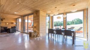 una sala da pranzo con tavolo e sedie di Chalet des Marmottes a Besse-et-Saint-Anastaise Altre 14 foto