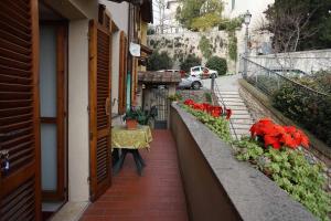 uma varanda com flores vermelhas no lado de um edifício em B&b In Piazza - San Gemini - Umbria em San Gemini