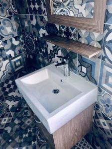 uma casa de banho com um lavatório branco e um espelho. em Jordan Tower Hotel em Amã