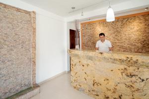 a man standing behind a counter in a brick wall at Yumkiin in Playa del Carmen