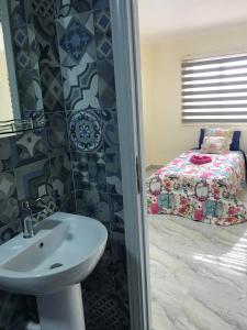1 dormitorio con 1 cama y baño con lavabo. en Jordan Tower Hotel en Amán