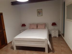 a bedroom with a white bed and two night stands at Casa Azul in Avis +38 photos
