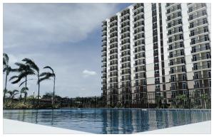 a large building with a swimming pool in front of it at BH Mangrove Condos in Mactan