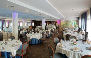 un comedor con mesas y sillas blancas en Hotel il Castelletto, en Casarile
