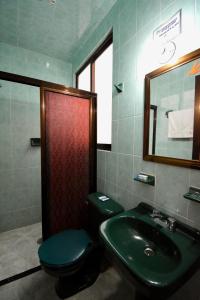 a bathroom with a green sink and a toilet at Hotel Yara in Ixtapan de la Sal