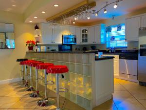 a kitchen with red bar stools at a counter at Villa-Coral-Ridge in Fort Lauderdale