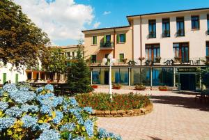 a building with a flower garden in front of it at Park Hotel Jolanda in San Zeno di Montagna