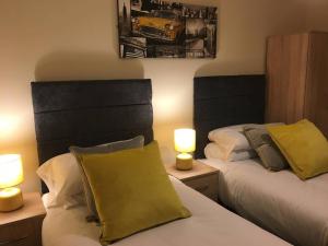 two beds in a room with two lamps on tables at StayNEC Moat House Birmingham - For Company, Contractor and Leisure Stays - NEC, HS2, JLR, Airport in Birmingham