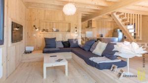 a living room with a blue couch and wooden walls at Le Paillaret in Besse-et-Saint-Anastaise