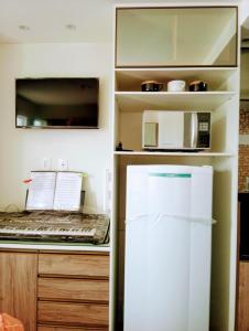 uma cozinha com um frigorífico e um micro-ondas em Flat em Cabo Frio em Cabo Frio