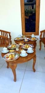 einem Holztisch mit Teller mit Lebensmitteln darauf in der Unterkunft Gio's Place in Labuan Bajo